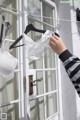 A person holding a white bra hanging on a clothes line.