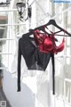 A red bra hanging on a clothes rack in front of a window.