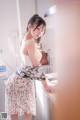 A woman standing in a kitchen next to a sink.