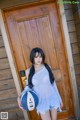 A woman holding a basketball in front of a wooden door.