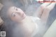 A woman in a bathtub with steam coming out of her body.