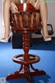 A woman sitting on top of a wooden chair.