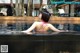 A woman in a pink bikini sitting in a pool.