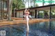 A woman in a pink bikini standing in a pool.