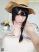 A woman in a straw hat is taking a selfie.