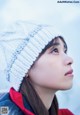 A woman wearing a white knitted hat in the snow.