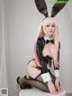 A woman in a bunny costume sitting on a stool.