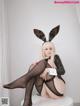 A woman in a bunny costume sitting on a stool.