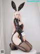 A woman in a bunny costume sitting on a stool.