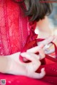 A woman in a red dress holding a red ribbon.