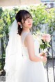 A woman in a wedding dress holding a bouquet of flowers