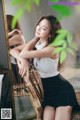 A woman sitting on a chair in front of a mirror.