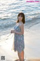 A woman standing on a beach next to the ocean.