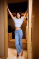 A woman standing in a closet with her arms outstretched.