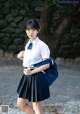 A woman in a school uniform is posing for a picture.