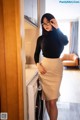 A woman standing in front of a washer and dryer.