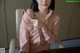 A woman in a pink shirt sitting at a table.