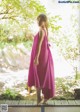 A woman in a pink dress standing on a wooden platform.