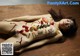 A naked woman laying on a wooden table covered in sushi.