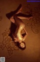 A naked woman laying on the floor in a room.