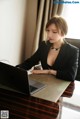 A woman sitting at a table with a laptop computer.