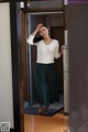 A woman standing in front of a refrigerator in a room.